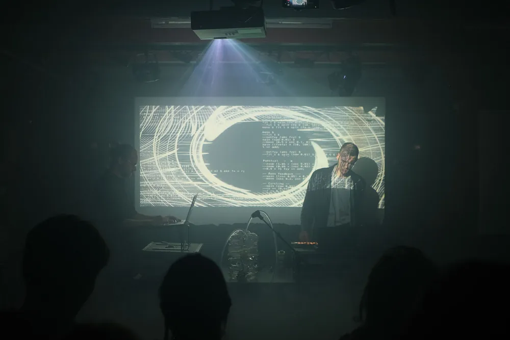 Sporo Wody performing live, surrounded by projected light.