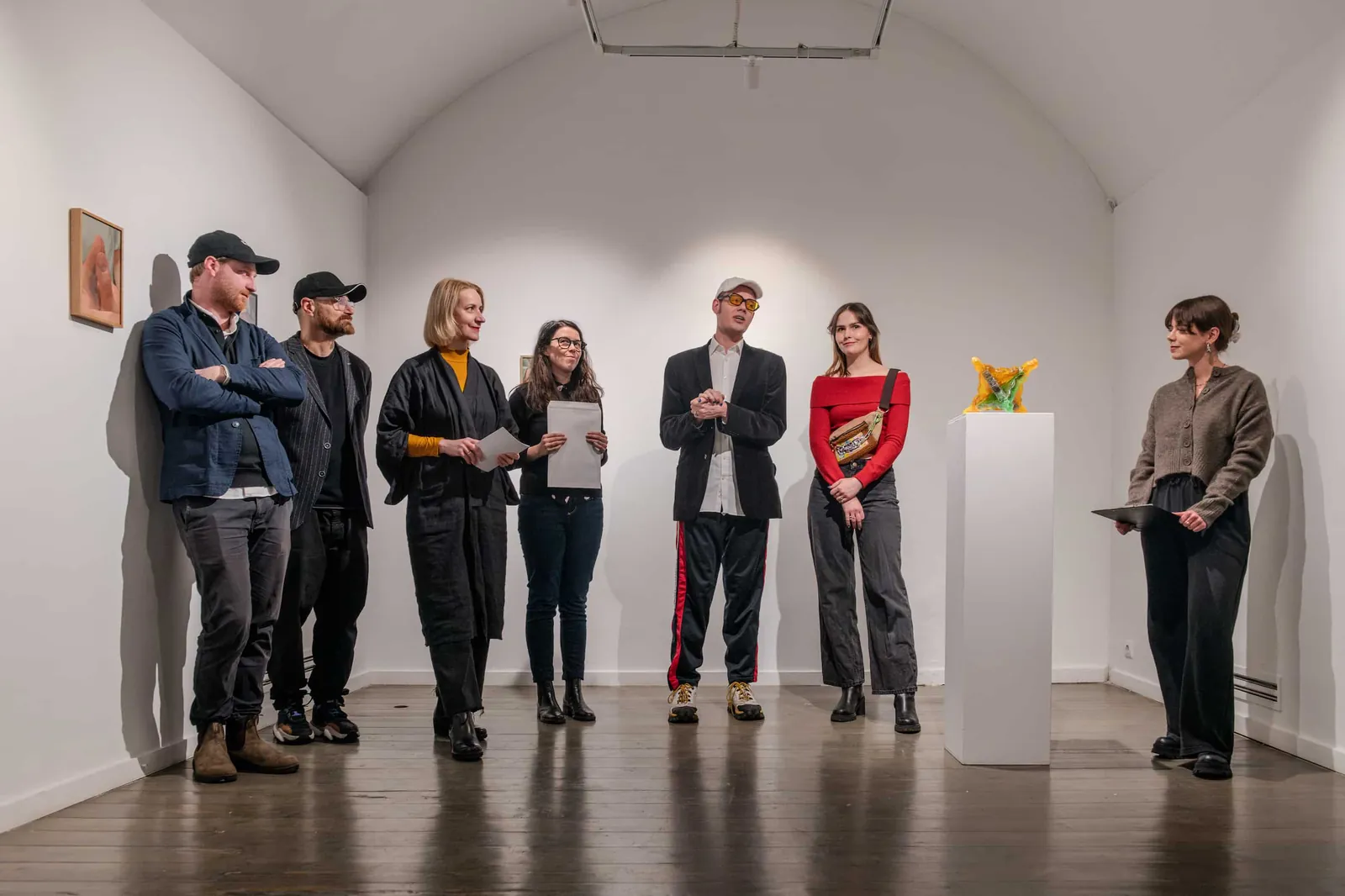 Visitors standing in a white vaulted gallery at the exhibition opening.